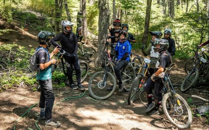 Coach explicando la técnica al grupo en el bosque